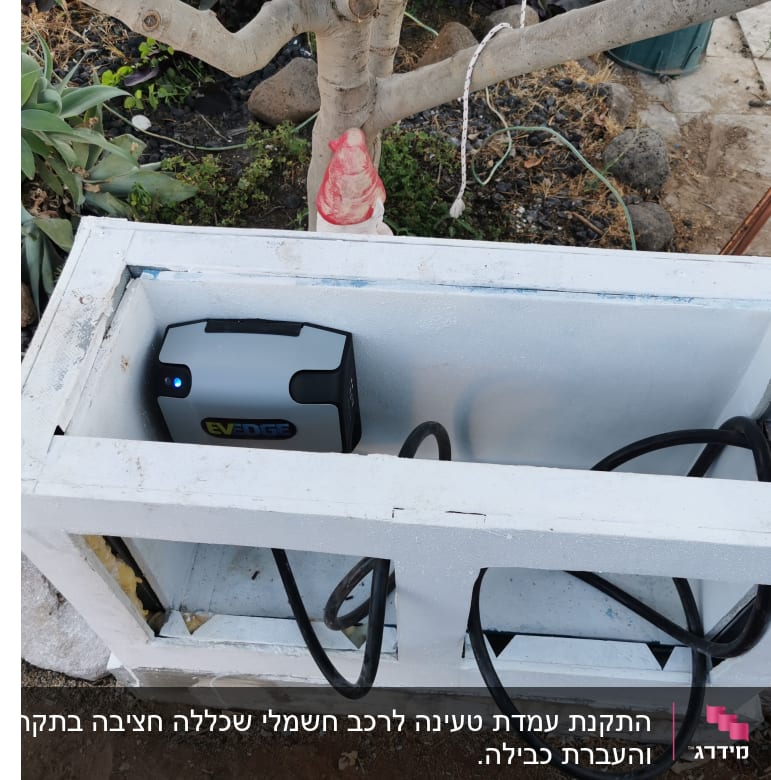 מטען חשמלי עם כבל בתוך תיבה לבנה